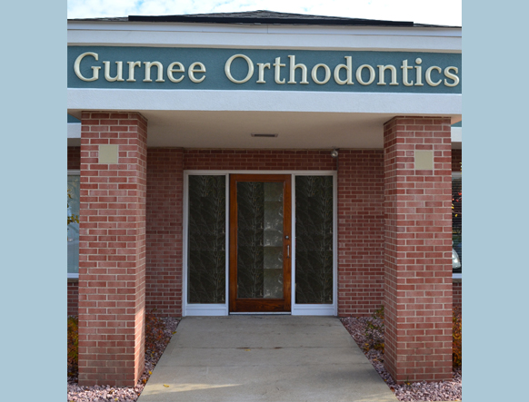 Gurnee, smiling and wearing glasses